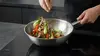 Stalowy wok Demeyere Specialities z potrawą na płycie indukcyjnej.