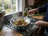 Stalowy wok Demeyere Specialities, 7-warstwowy, z dodatkowym uchwytem, na kuchence gazowej.