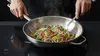 Stalowy wok Demeyere Specialities z potrawą z makaronem i warzywami