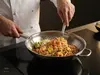 Stalowy wok Demeyere Specialities z potrawą na kuchence