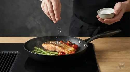 Scanpan Pro SB+ patelnia tytanowo-ceramiczna z łososiem i warzywami na kuchence.