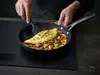Tytanowo-ceramiczna patelnia Scanpan Pro SB+ Ø 32 cm z omletem i warzywami.