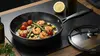 Scanpan Pro SB+ tytanowo-ceramiczna patelnia Ø 28 cm z pokrywką na kuchennym blacie.