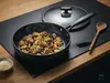 Tytanowo-ceramiczna patelnia Scanpan Pro SB+ z potrawą na drewnianym blacie