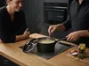 Tytanowo-ceramiczny rondel Scanpan Pro SB+ z pokrywką, 1,8 l, czarny, na blacie kuchennym.