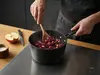 Tytanowo-ceramiczny rondel Scanpan Pro SB+ z warzywami na kuchence.