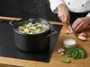 Tytanowy garnek Scanpan Pro SB+ 6,5L z daniem z kurczaka i szpinaku, obok krojona cebula.
