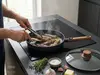 Patelnia WOLL Eco Logic QXR Wood z tytanową powłoką i drewnianym uchwytem podczas smażenia.