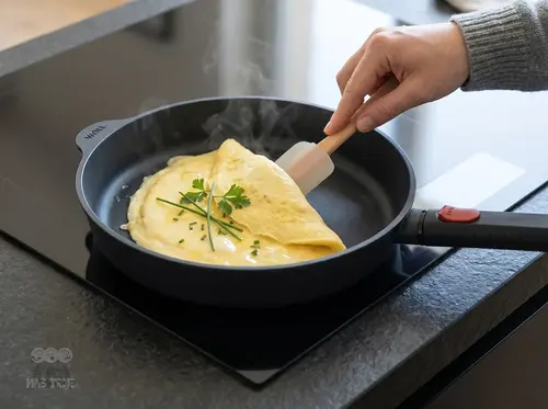 Patelnia Woll z omletem na kuchence indukcyjnej w nowoczesnej kuchni.