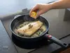 Patelnia Woll z rybą, kaparami i cytryną na kuchence indukcyjnej.