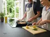 Produkt kuchenny firmy produkt w nowoczesnej kuchni z otwartymi drzwiami na ogród.