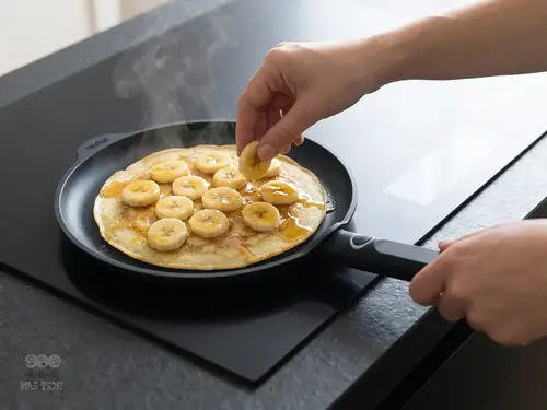 Eco Logic QXR WOLL – tytanowa patelnia do naleśników z bananami, nieprzywierająca, Ø 26 cm, czarna.