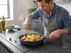 Patelnia Produkt w kuchni, mężczyzna gotujący makaron z warzywami