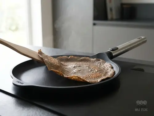 Tytanowa patelnia WOLL Eco Logic QXR PRO z naleśnikiem na kuchence indukcyjnej.