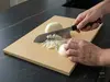 Japoński nóż Santoku Senzo Black Suncraft 33-warstwowy VG-10 do warzyw na desce podczas krojenia cebuli