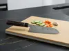 Senzo Black Suncraft – czerniony, 33-warstwowy nóż Santoku VG-10 na desce z warzywami i czosnkiem