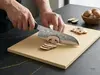 Suncraft Senzo Black – 33-warstwowy nóż Santoku 16,7 cm krojący pieczarki na desce w nowoczesnej kuchni