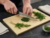 Senzo Black Suncraft – japoński nóż kucharza Gyuto 20 cm do siekania na desce, świeży koper obok