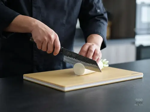 Suncraft Senzo Finest Bunka 16,5 cm – japoński nóż do warzyw z ostrzem SPG STRIX na desce kuchennej