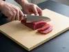 Suncraft Senzo Professional Santoku SG2 – japoński nóż 16,5 cm krojący tuńczyka na jasnej desce kuchennej
