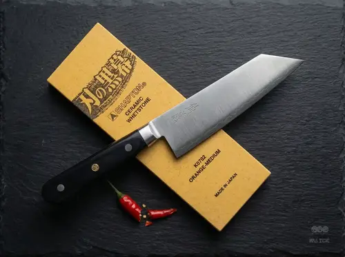 Japoński nóż Bunka Suncraft Senzo Professional SG2 na ostrzałce Shapton i czarnym tle z papryczką chili