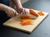 Suncraft Gyuto Senzo Professional – japoński nóż mistrzowski SG2 21 cm, krojenie marchewki na desce kuchennej