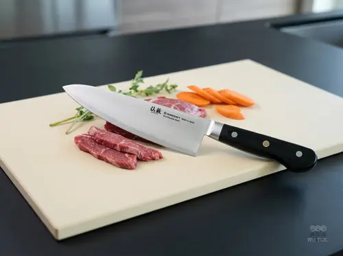 Japoński nóż Gyutoh Suncraft Senzo Professional SG2, 21 cm, na desce z mięsem i warzywami w kuchni